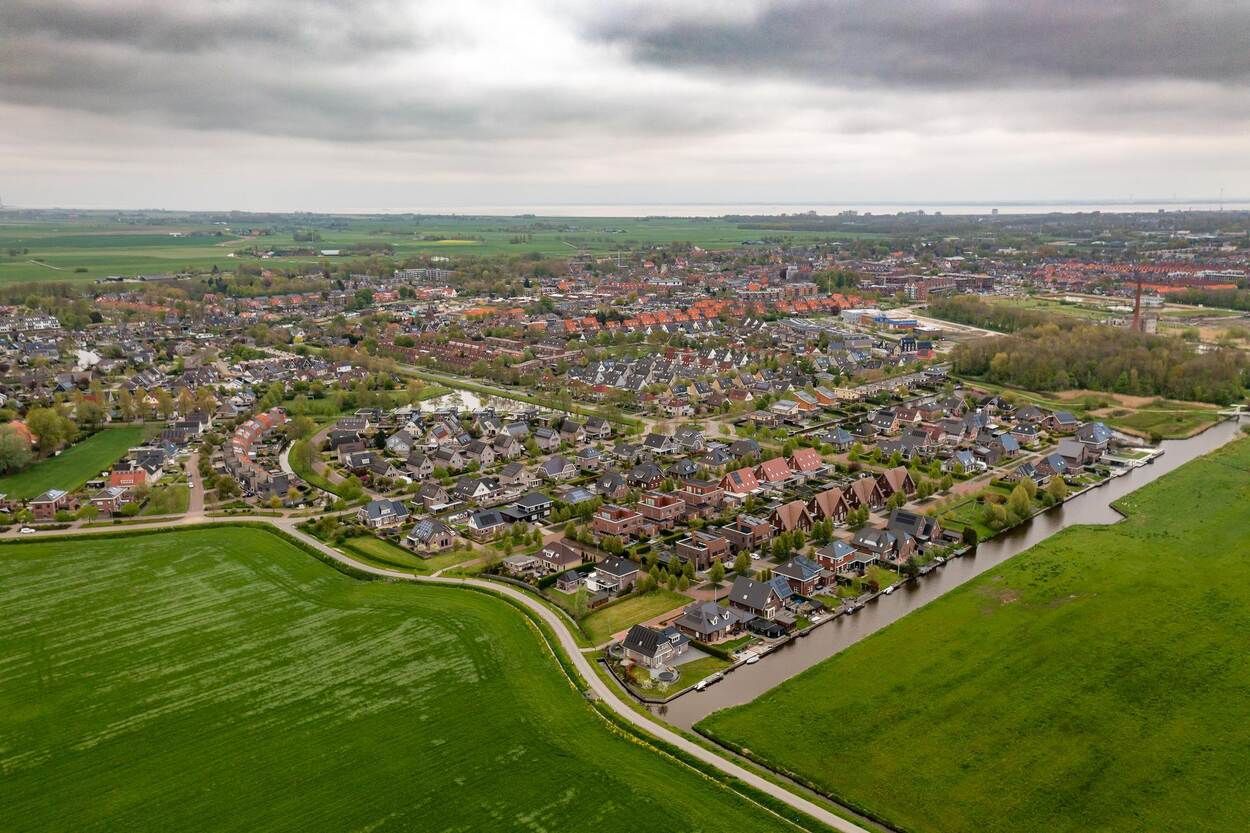 luchtfoto van dorp en weilanden
